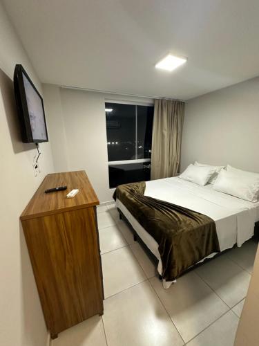 a hotel room with a bed and a television at Apartamento completo em Salinópolis in Salinópolis