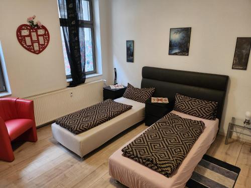 a hotel room with two beds and a chair at MD- City, chic, Erdgeschoss, BESTPREIS- Leistung, wir bieten 1 Dreibettzimmer, plus DZ bis 5 Personen , Küche, Bad in Magdeburg