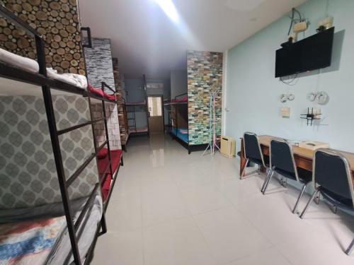 a room with bunk beds and a table and chairs at FriendTogether Armthong in Ban Khlong Kathon