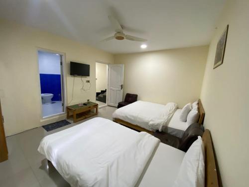 a hotel room with two beds and a tv at River View Hotel Shigar in Shigar