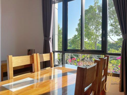 a dining room table with chairs and a large window at Kim Minh Apartment & Hotel in Vung Tau