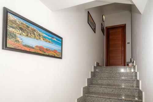 a painting hanging on a wall next to a staircase at Affittacamere - Il Vicoletto in Porto Torres