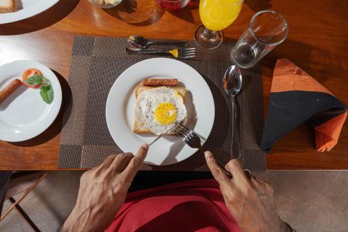 a person sitting at a table with a plate of food at Ark Cabin Villa in Kandy