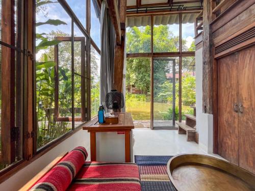 a living room with a large window and a tub at NernJamsai in Sop Poeng