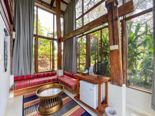 a living room with red couches and windows at NernJamsai in Sop Poeng