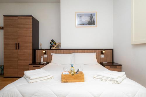 a bedroom with a large white bed with a wooden headboard at Affittacamere - Il Vicoletto in Porto Torres