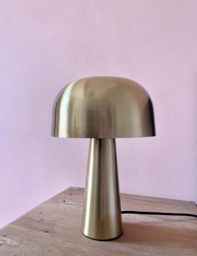a gold lamp sitting on top of a wooden table at Domaine Les Mûriers in Brignoles