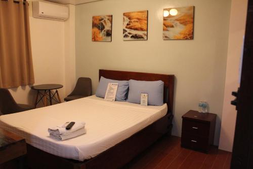 um quarto com uma cama com toalhas em Aqua Travel Lodge em El Nido