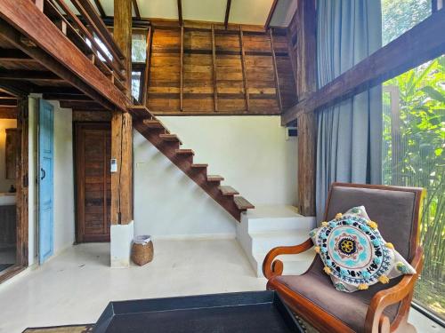 a living room with a chair and a staircase at NernJamsai in Sop Poeng
