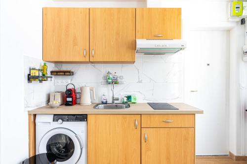une cuisine avec un évier et une machine à laver dans l'établissement GuestReady - Stylish Escape in Folie-Méricourt, à Paris