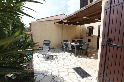 d'une terrasse avec une table et des chaises dans l'arrière-cour. dans l'établissement St Cyprien maison de vacances 6 personnes clim, à Saint-Cyprien