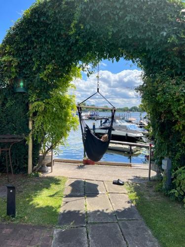 a hammock hanging from an archway over a body of water at Pension am Tiefen See in Potsdam