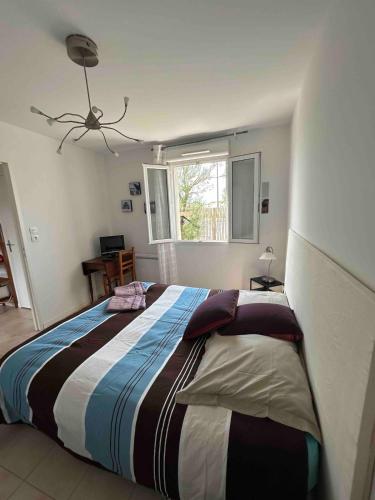 - une chambre avec un grand lit et une couverture rayée dans l'établissement Maison front de mer, vue océan, à Soulac-sur-Mer