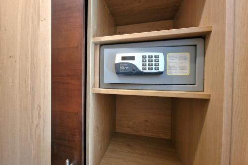 a television in a cabinet with a remote control at Landgasthof Trattnig in Schiefling am See