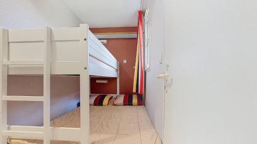 Ce lit superposé blanc se trouve dans un dortoir doté d'une chambre. dans l'établissement M-Bruyère 02-Moliets Charmant appartement pour 4 personnes proche golf et plage dans un résidence avec piscine, à Moliets-et-Maa