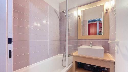 une salle de bain avec un lavabo, un miroir et une baignoire dans l'établissement M-Bruyère 02-Moliets Charmant appartement pour 4 personnes proche golf et plage dans un résidence avec piscine, à Moliets-et-Maa