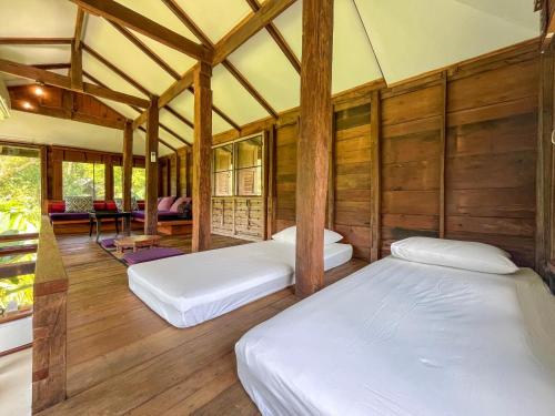 two beds in a room with wooden walls at NernJamsai in Sop Poeng