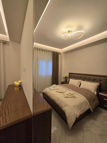 a bedroom with a large bed and a mirror at Villa Alexandros in Pogradec