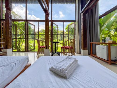 a bedroom with two beds and a large window at NernJamsai in Sop Poeng