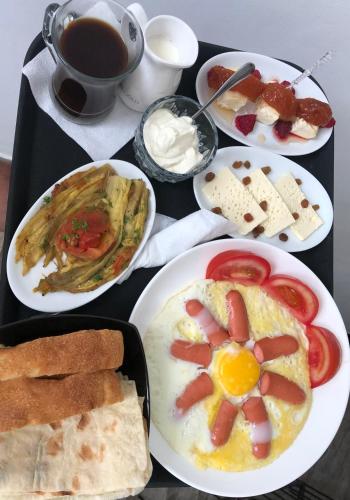 a table with plates of breakfast foods and a cup of coffee at ApartHotel in Alaverdi in Alaverdi