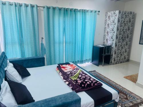 a bedroom with a bed and blue curtains at Krishnabalram wellness & Ayurveda centre in Rishīkesh