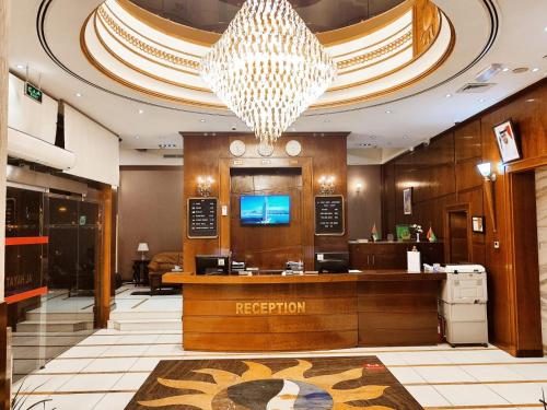 a hotel lobby with a reception desk and a chandelier at Al Hayat Hotel Apartments in Sharjah