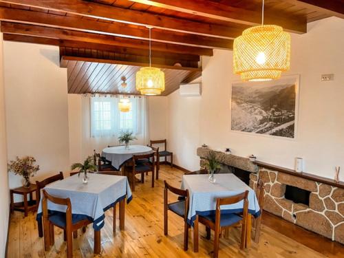a dining room with tables and chairs and a fireplace at Pousadinha de Paradela in Paradela
