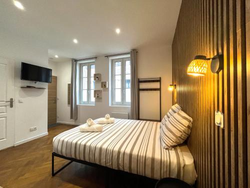 une chambre avec un lit avec deux animaux en peluche dessus dans l'établissement Appartements Cosy & Chic- Hyper Centre AGEN, à Agen