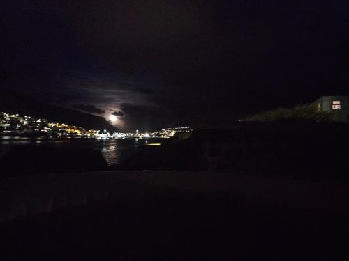 a view of a city at night with a moon at Sea View Suite in Klaksvík