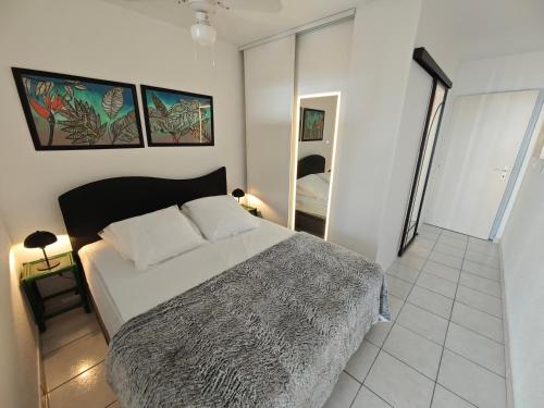 une chambre avec un grand lit et un miroir dans l'établissement Appartement Village Naturiste Paradoxia, au Cap d'Agde
