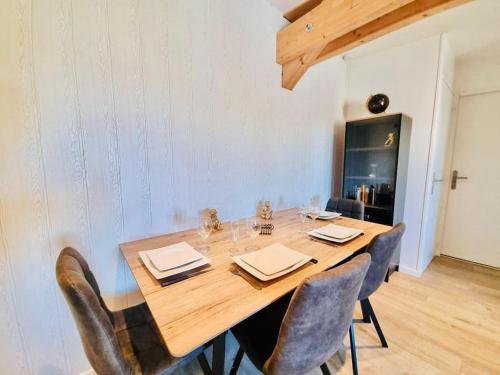 une table à manger avec des chaises et une grande table en bois dans l'établissement Rue de Reims super T3 tout équipé et parking privé, à Bétheny