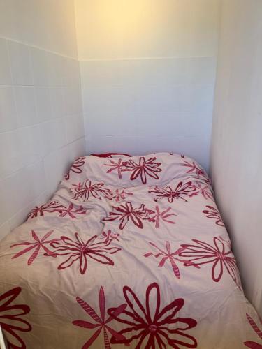 - un lit avec des fleurs rouges dans une chambre dans l'établissement Appart 2 pièces proche plage, à Saint Pierre La Mer