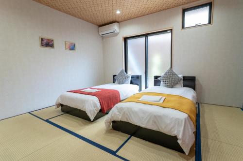 um quarto com duas camas e uma janela em nestay東九条01左側 em Quioto