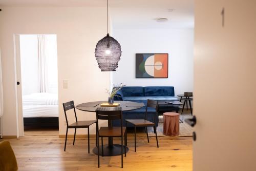 a living room with a table and chairs and a couch at Das Stadthouse 2 in Gunskirchen