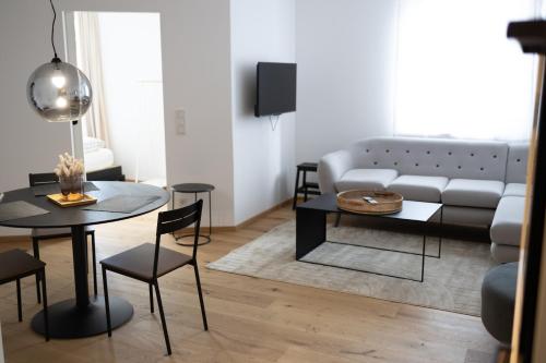 a living room with a couch and a table at Das Stadthouse 2 in Gunskirchen