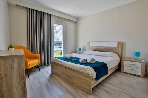 a bedroom with a bed and a chair and a window at Furnaka Eco Village in Lourinhã