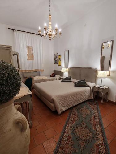 a bedroom with two beds and a chandelier at Residenza Levante in Syracuse