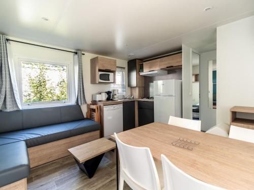 - une cuisine et une salle à manger avec une table et un canapé dans l'établissement Flower Camping Echo du Malpas, à Monceaux-sur-Dordogne