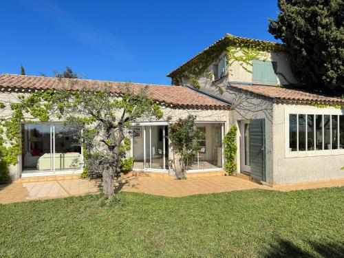 une maison avec un arbre dans la cour avant dans l'établissement Villa Notre-Dame avec piscine, à Rochefort-du-Gard