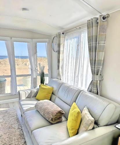 a living room with a white couch with yellow pillows at 101 Sapphire Tees Bay in Redcar