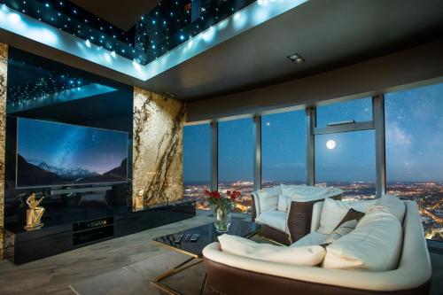 a living room with a white couch and a large window at 30th+ Floor Apartments in Sky Tower in Wrocław