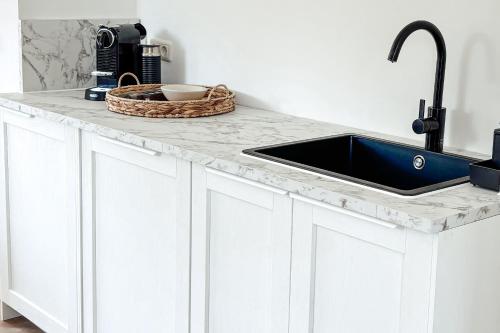 Una cocina blanca con fregadero y encimera. en Ferienhaus NATÜRLICH AM BODDEN, en Michaelsdorf