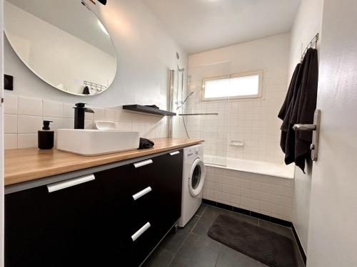 une salle de bain avec un lavabo et une machine à laver dans l'établissement Le cocon des Maraîchers & Parking et 400 m from train station, à Avon