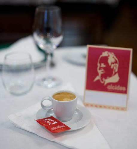 a cup of coffee on a table with a wine glass at Hotel Alcides in Ponta Delgada