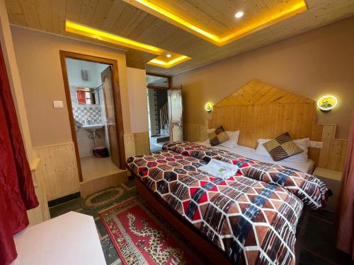a bedroom with a large bed with a wooden headboard at La Voglia-Old Manali in Manāli