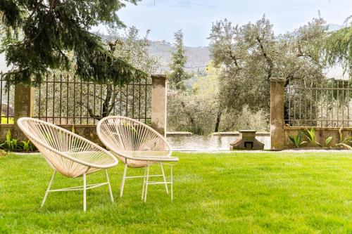 two chairs sitting in the grass in a yard at Tenuta di Tramonte Boutique Hotel in Lucca