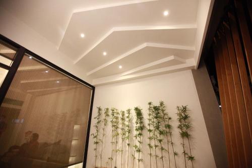 um quarto com uma parede com plantas na parede em Bai Ji Yi B&B em Hengchun Old Town