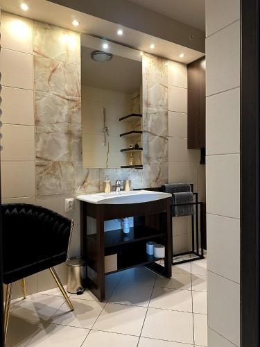a bathroom with a sink and a mirror at Opera Apartment Centrum PKS PKP in Częstochowa