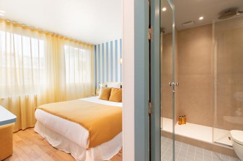 - une chambre avec un lit, une douche et une salle de bains dans l'établissement Paris Home Collection - Serviced Apartments Champs-Elysées - Rue de Ponthieu, à Paris