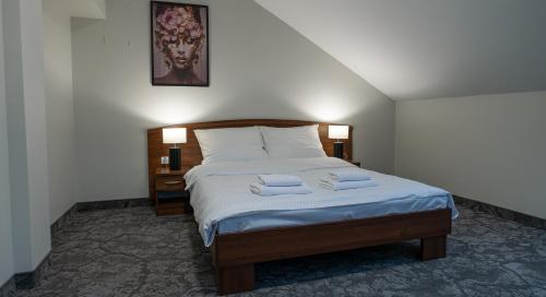 a bedroom with a bed with two towels on it at Forrest in Głogów Małopolski